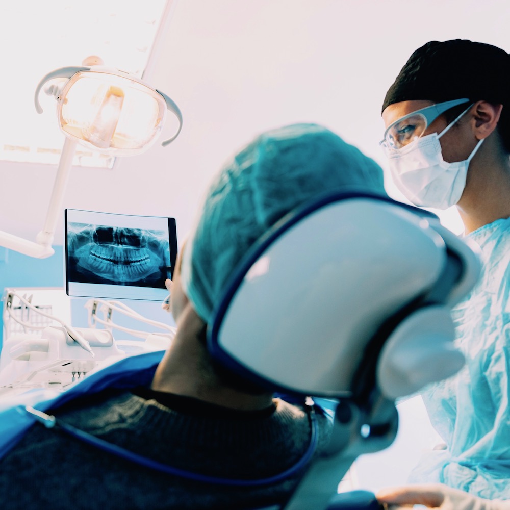 Doctor talking with her patient and teaching a radiograph.